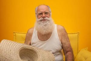 vieil homme à longue barbe blanche coiffé d'un grand chapeau de paille. photo