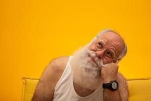 vieil homme avec une longue barbe sur fond jaune. senior avec pleine barbe blanche. vieil homme avec une longue barbe avec tristesse. photo