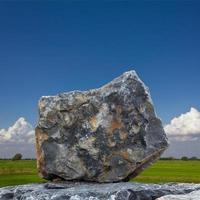 un grand granit avec des nuages du ciel en toile de fond. photo