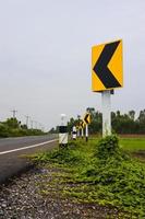 panneaux indiquant des courbes près de la route goudronnée en thaïlande rurale. photo