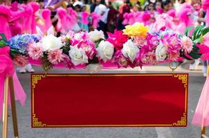 étiquette rouge chinoise avec des fleurs artificielles roses. photo