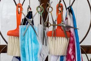 ciseaux et brosse coupe de cheveux et pendaison avec des vêtements et un masque. photo