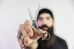 barbier avec une longue barbe à l'aide de ciseaux photo