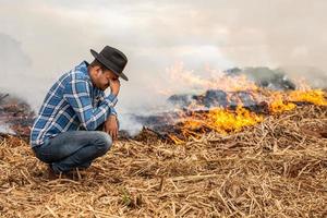 fermier désespéré que le feu frappe sa ferme. brûlé les jours secs détruisant la ferme. photo