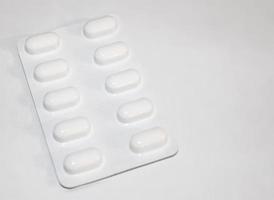 concept de pharmacie pharmacie. packs de pilules blanches emballées dans des blisters avec espace de copie isolé sur fond blanc. se concentrer sur le premier plan, bokeh doux. photo
