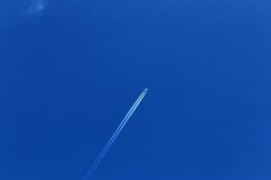 Contraintes de condensation des avions dans le ciel bleu entre quelques nuages photo