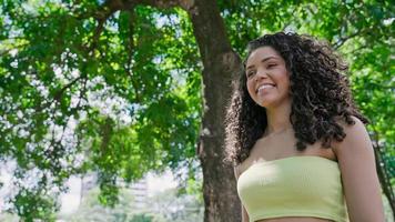 jolie femme latine marchant dans le parc par une journée ensoleillée et souriante. photo