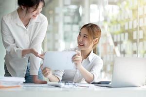 une jeune femme d'affaires asiatique travaille ensemble pour analyser le travail au bureau. photo