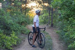 jeune athlète à cheval sur son vélo professionnel de montagne ou de cyclocross dans la forêt