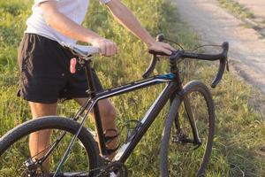 portrait de jeune cycliste debout seul sur la route en forêt photo