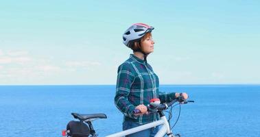 jeune femme cycliste en casque en journée d'été ensoleillée photo