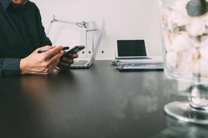 homme d'affaires ou designer utilisant un téléphone intelligent avec ordinateur portable et tablette numérique dans un bureau moderne photo