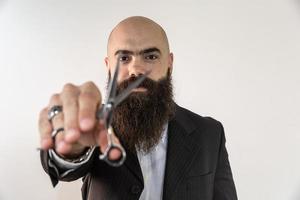 barbier avec une longue barbe à l'aide de ciseaux photo