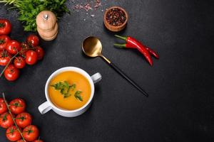 délicieuse soupe de purée de citrouille fraîche décorée de persil dans une assiette blanche photo