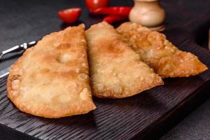 chebureks faits maison remplis de viande hachée et d'oignons, cuisine caucasienne traditionnelle photo