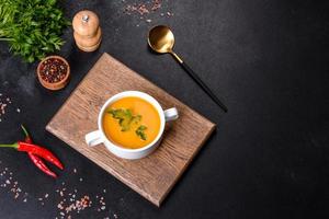 délicieuse soupe de purée de citrouille fraîche décorée de persil dans une assiette blanche photo