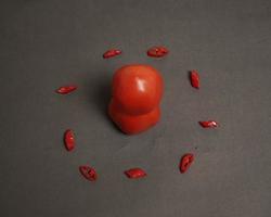 la combinaison de tomates fraîches, de piments rouges et d'œufs forme un visage souriant. ingrédients de cuisine prêts à être servis. flou de mise au point, inspiration d'arrière-plan. combinaison de couleurs noir et rouge. photo