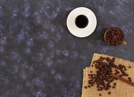 tasse à café et grains de café sur fond sombre. vue de dessus photo