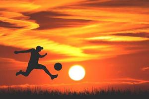 silhouette de joueurs de football dans la soirée. concept de football est populaire partout dans le monde. photo