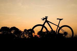 silhouette d'un vélo de montagne dans la soirée. idées de remise en forme et d'aventure photo
