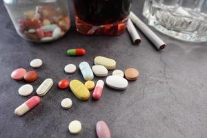 alcool, pilules et cigarette sur table photo