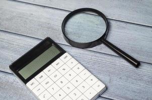 calculatrice et loupe sur table en bois photo