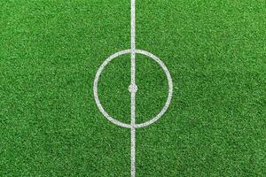 vue de dessus du centre du terrain de football avec motif de lignes blanches.