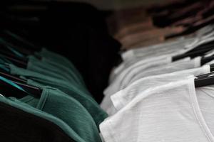 quelques vêtements usagés accrochés à un rack dans un marché aux puces. fond de robe. mise au point sélective. photo