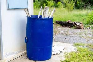 image d'une pile de tubes de lampes au néon désaffectés et mis au rebut en attente de recyclage dans la corbeille bleue avec fond nature. de nombreux tubes fluorescents plus anciens ont été laissés à la poubelle. photo