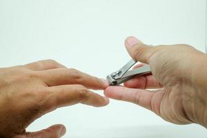 gros plan femme couper ses ongles avec coupe-ongles isolé sur fond blanc. concept de soin des ongles et de soins de santé. photo