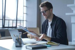 jeune homme d'affaires allemand dans des verres discutant des rapports de tableau de calcul avec des partenaires en ligne photo