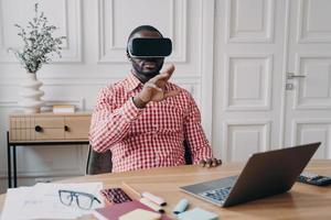 jeune homme d'ethnie africaine entrepreneur dans des lunettes de casque vr immergé dans les jeux 3d photo