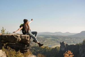 Youmg femme avec sac à dos debout sur l'ancien château allemand dans le parc national de la Suisse saxonne photo