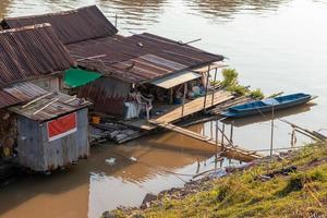 vieille maison en bois sur un radeau flottant sur la rivière. photo