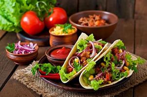 tacos mexicains avec viande, légumes et oignon rouge photo