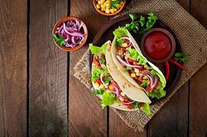 tacos mexicains avec viande, légumes et oignon rouge photo