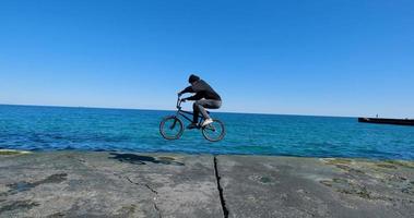 jeune homme avec planche à roulettes relaxant près de la mer photo