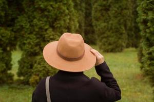femme au chapeau marchant seule dans le magnifique parc d'automne photo