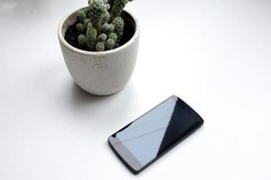 téléphone portable noir sur fond blanc, vue de dessus du smartphone et des décorations intérieures photo