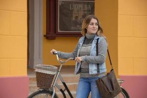 jeune femme cycliste utilise un téléphone portable, arrière-plan urbain photo