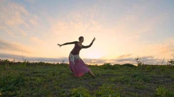 danse féminine heureuse dans les champs d'été pendant le beau coucher de soleil photo