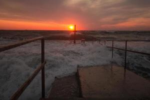 beau paysage marin au lever du soleil, ciel coloré rose et orange et tempête dans la mer. photo