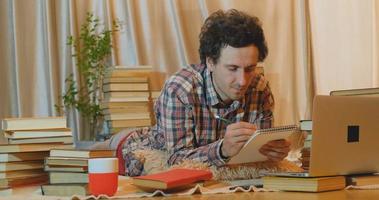 jeune homme lit des livres à la maison photo