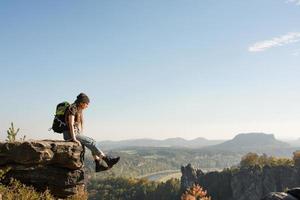 Youmg femme avec sac à dos debout sur l'ancien château allemand dans le parc national de la Suisse saxonne photo