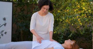 femme faire un massage chinois traditionnel à l'extérieur dans le jardin d'été photo