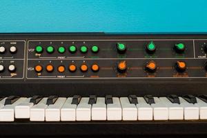 ancien synthétiseur avec interrupteurs colorés sur fond bleu photo