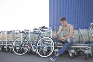 jeune homme marche avec vélo fixie, arrière-plan urbain, photo de hipster avec vélo aux couleurs bleues