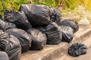 de nombreux sacs en plastique noirs remplis d'ordures. photo