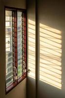 ombre du soleil sur le mur avec de vieilles fenêtres à persiennes. photo