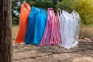 variété de sacs en plastique suspendus à la clôture de barbelés. photo